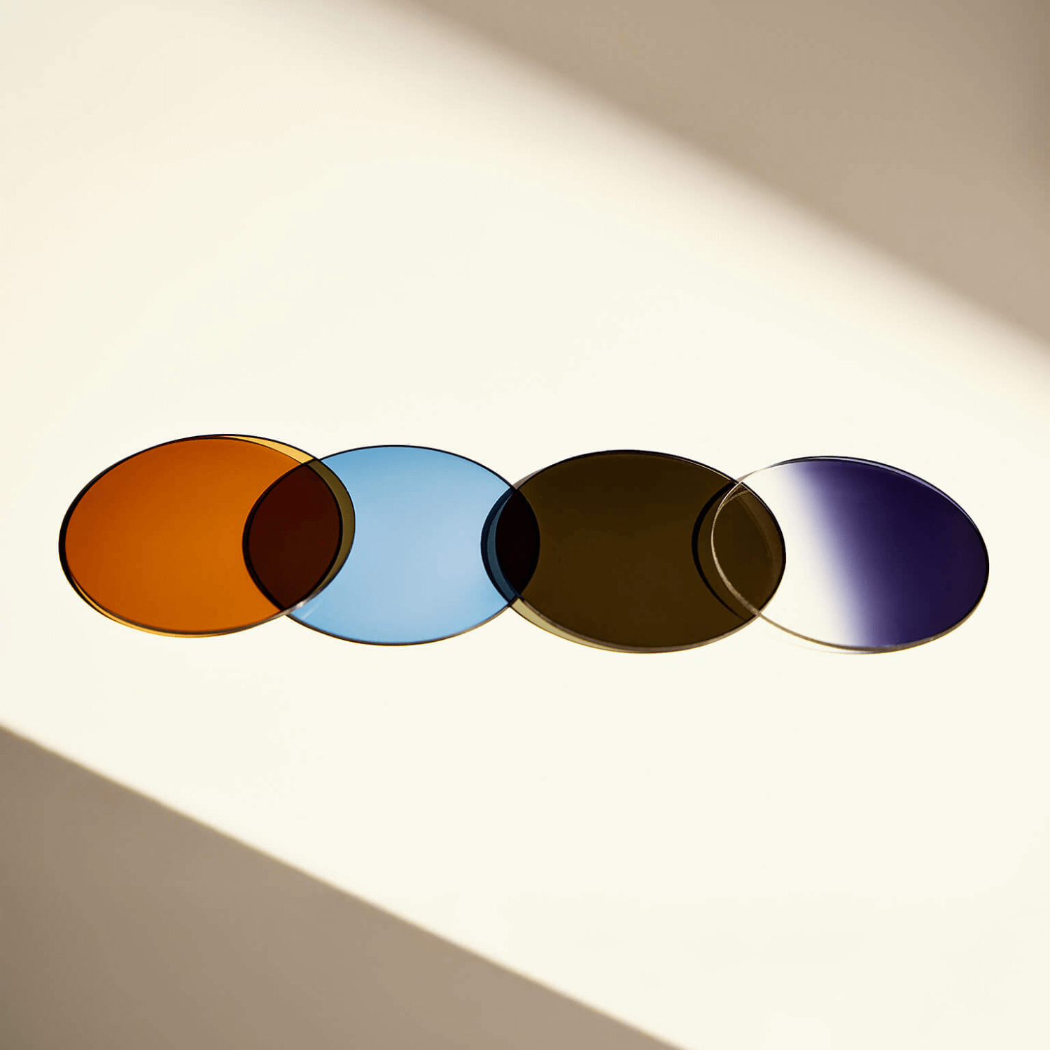 “Four Zeiss sun lenses in warm amber, blue, brown, and gradient purple tones displayed under natural light, showcasing ME & JOE custom lens options.”