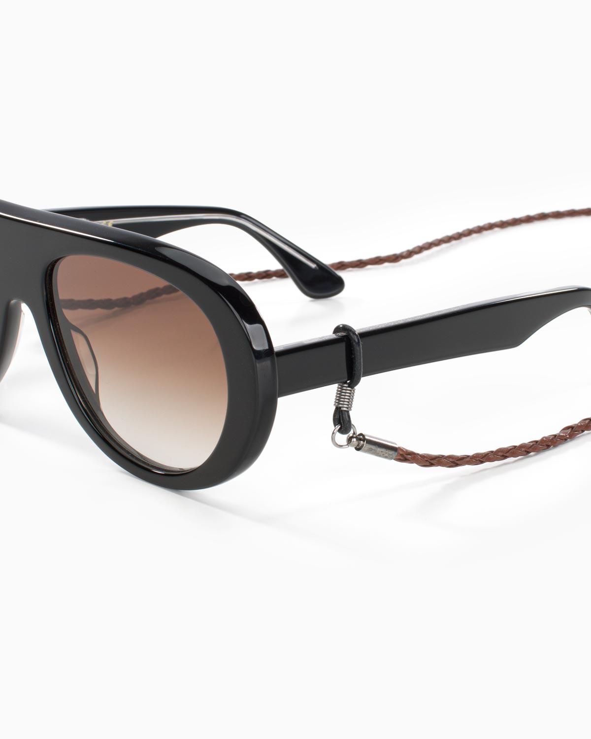 Close-up of brown braided eyewear chain attachment on sunglasses