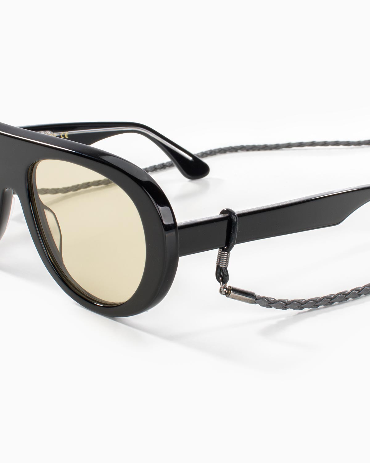 Close-up of brown braided eyewear chain attachment on sunglasses