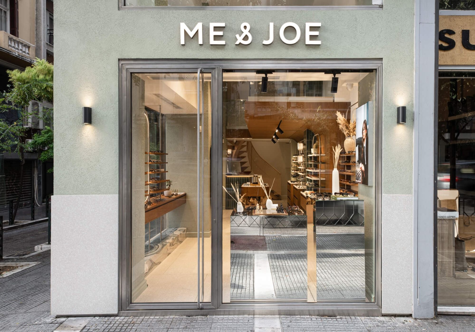 ME & JOE Tsimiski store exterior with glass entrance and illuminated signage