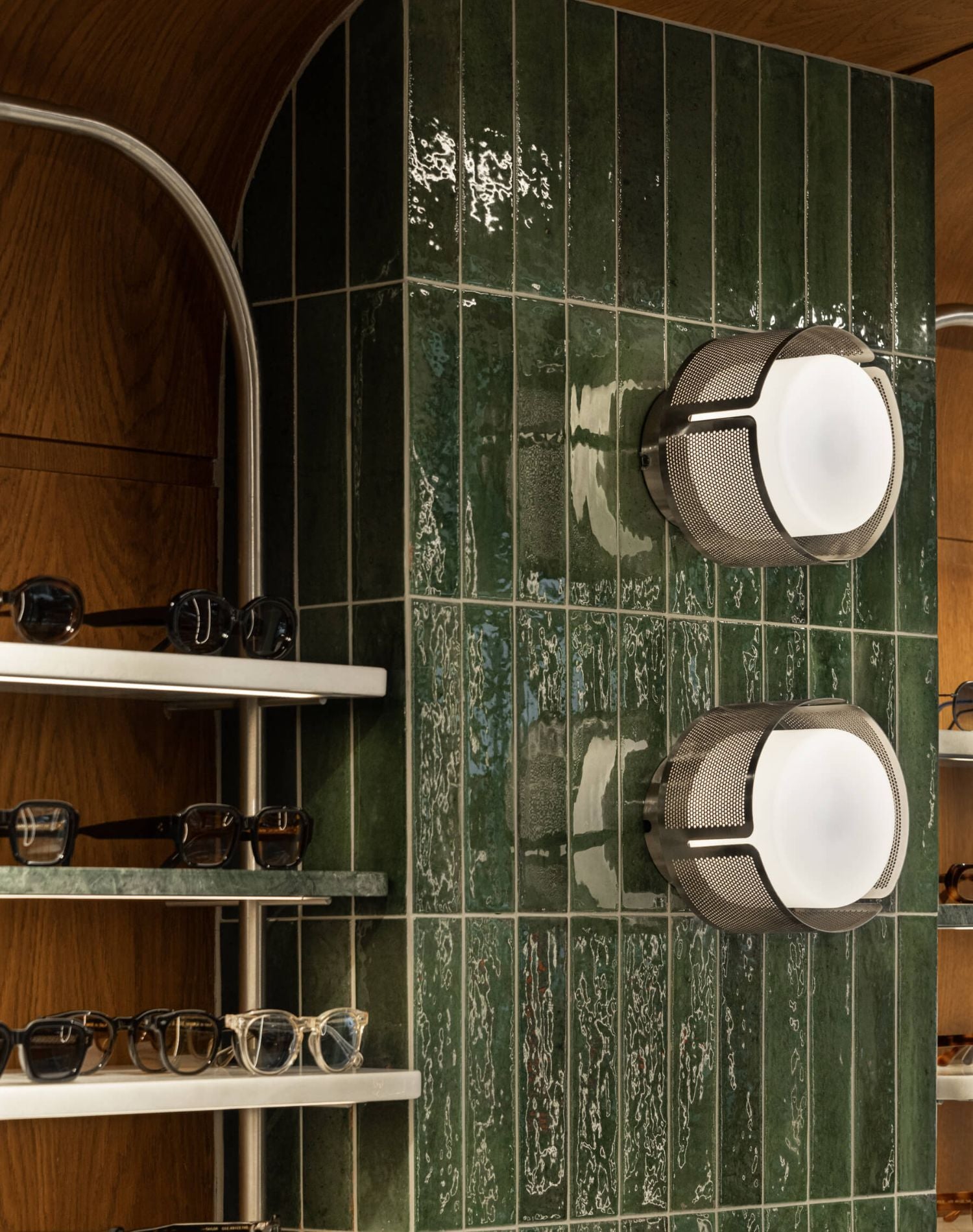 Interior view of the ME & JOE Tsimiski store featuring wall displays, sunglasses shelves, and oak-and-green design elements.